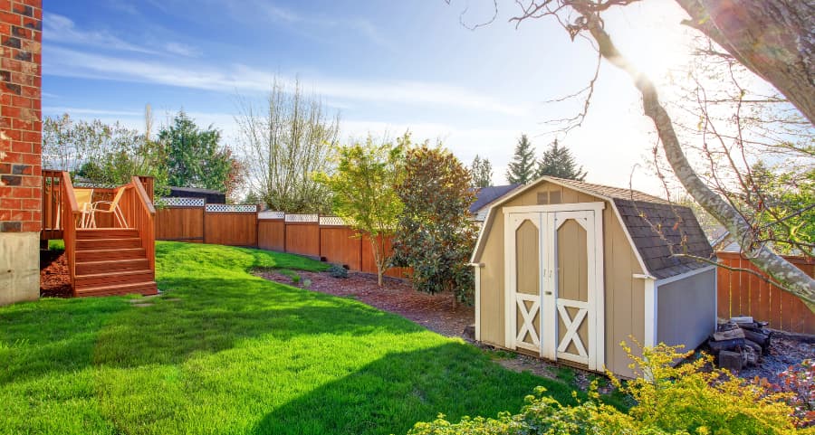 Fenced backyard with storage shed in Wichita